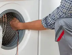 Dryer repair technician diagnosing and servicing a clothes dryer in Kansas City, MO